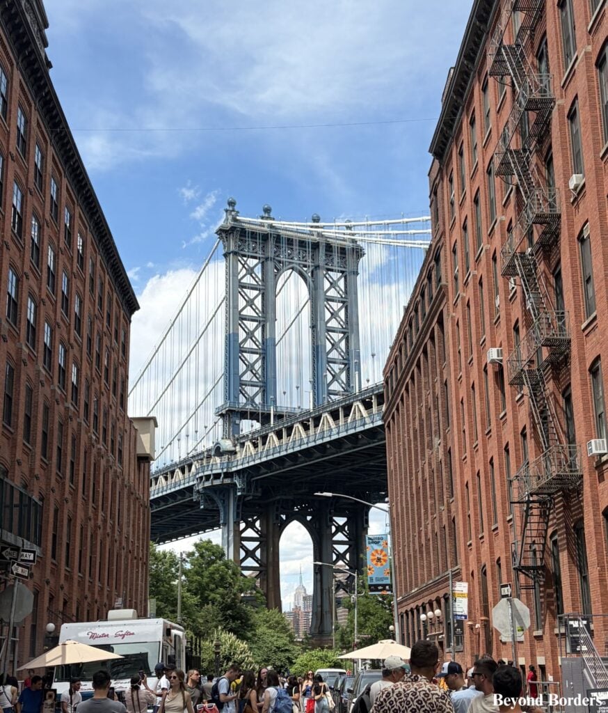The iconic Manhattan Bridge view in DUMBO on Washington Street, with the Empire State Building in the distance in Brooklyn, NYC