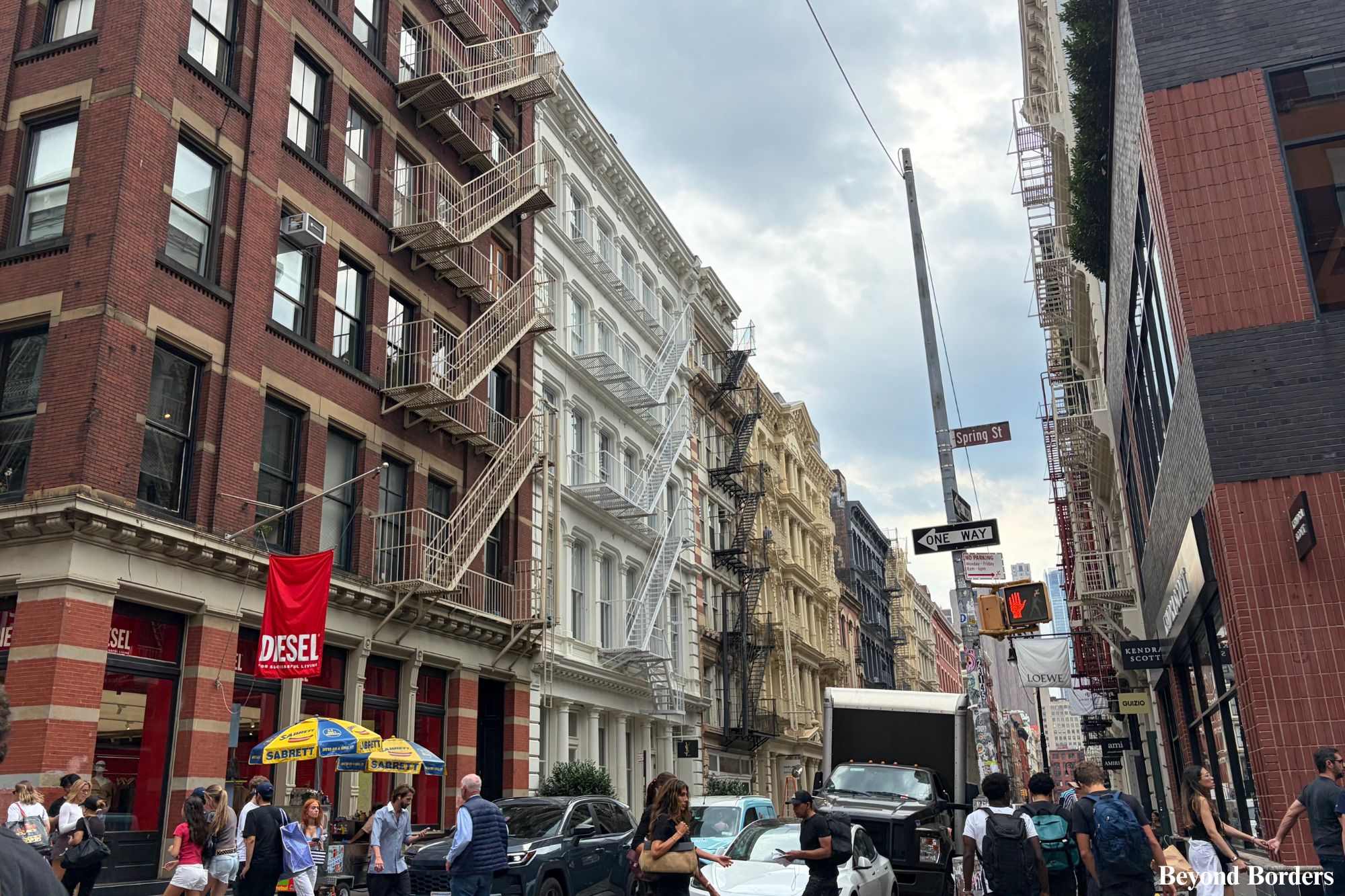 The intersection of Greene St and Spring St in SoHo, NYC with cast-iron architecture