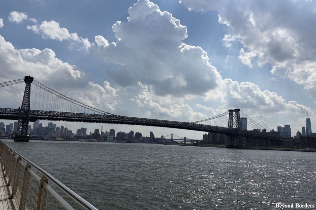 Williamsburg Bridge seen from Domino Park with One WTC to the far right and both the Manhattan and Brooklyn Bridges in the distance in Williamsburg, Brooklyn, NYC